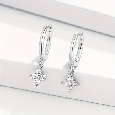 Silver-tone huggie hoop earrings with dangling four-leaf clover charms