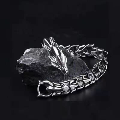 Silver-tone dragon chain bracelet for men on dark stone background