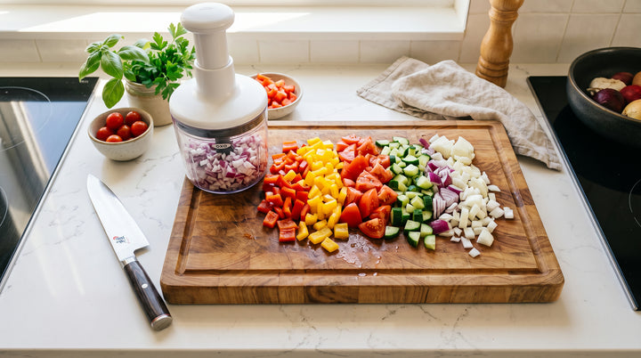 Vegetable chopper with freshly diced peppers and onions in a sunny modern kitchen