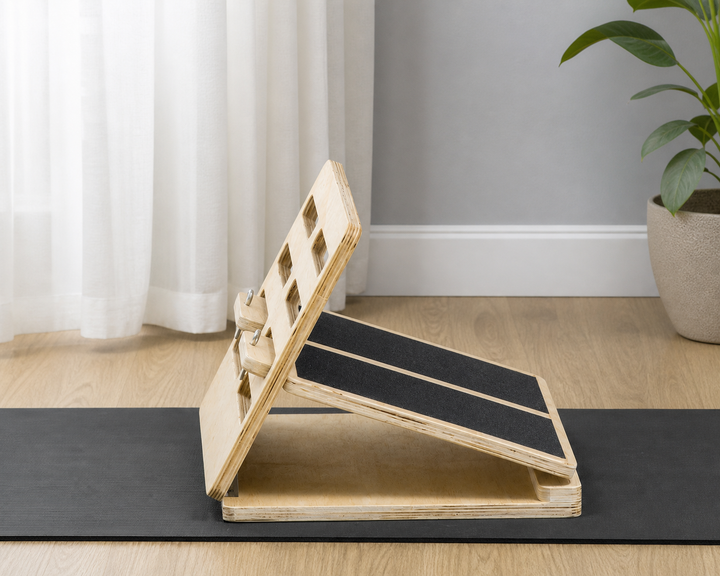 Natural plywood adjustable calf stretch board with black grip panels in a home fitness space