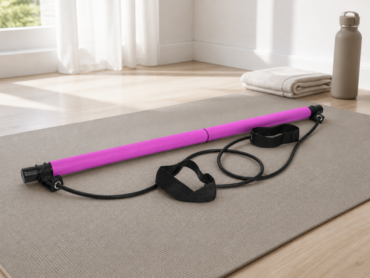 Pink Pilates bar with black resistance tubes and straps on an exercise mat