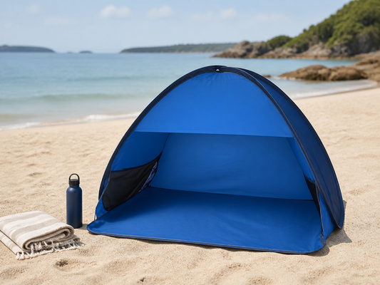 Blue pop-up beach tent set up on sand beside calm water
