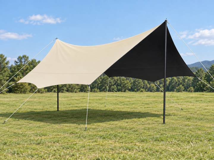 Two-tone cream and black camping canopy tent anchored on a sunny grassy campsite