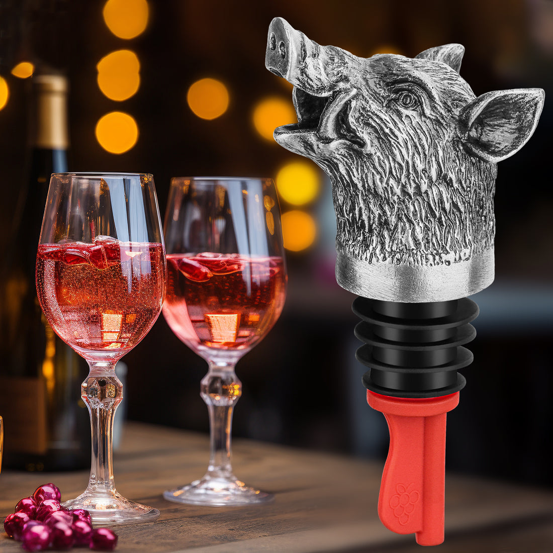 Dark silver boar head pourer in a bottle beside two glasses of rose wine