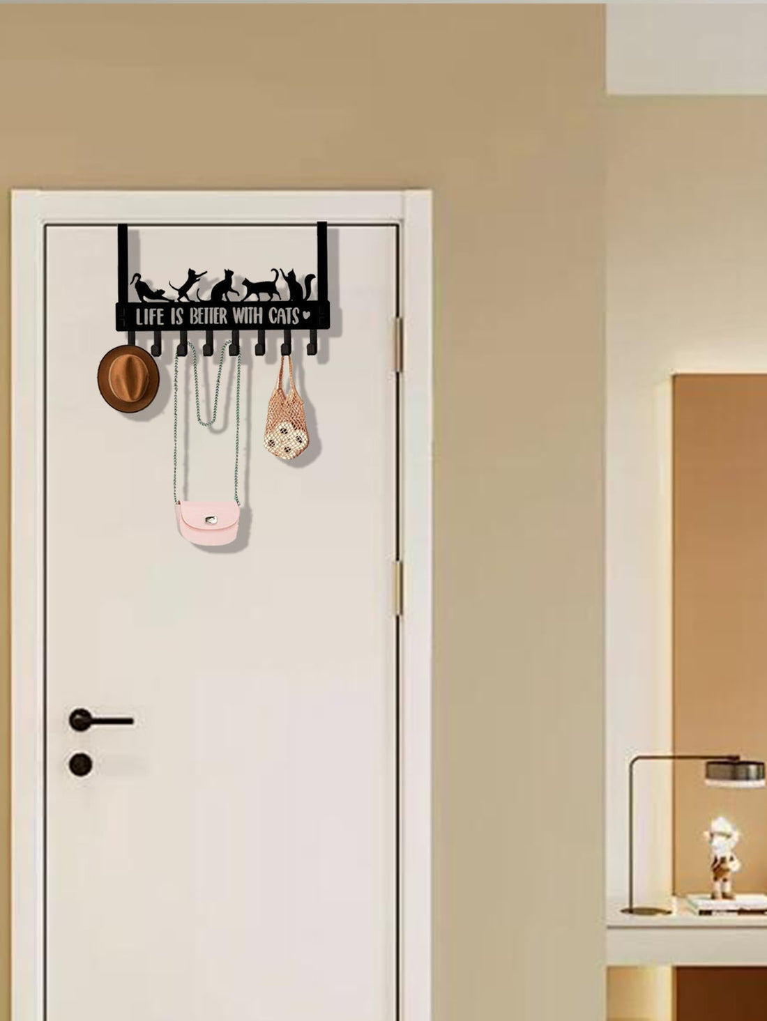 Cat hook rack over a white door in a bright room