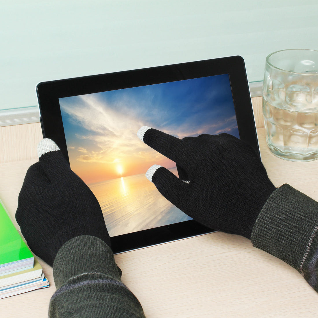 Gloved hand tapping a tablet screen
