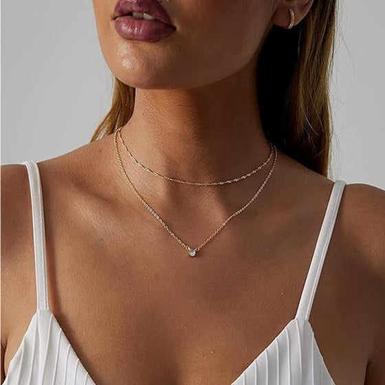 Woman wearing the gold layered solitaire pendant and rope chain necklaces