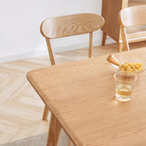 Modern oak dining chairs paired at a dining table