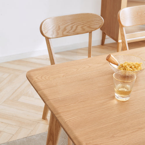 Modern oak dining chairs paired at a dining table