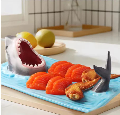 Ceramic serving plate sculpted with an open-mouthed shark's head rising from a wave-textured tray