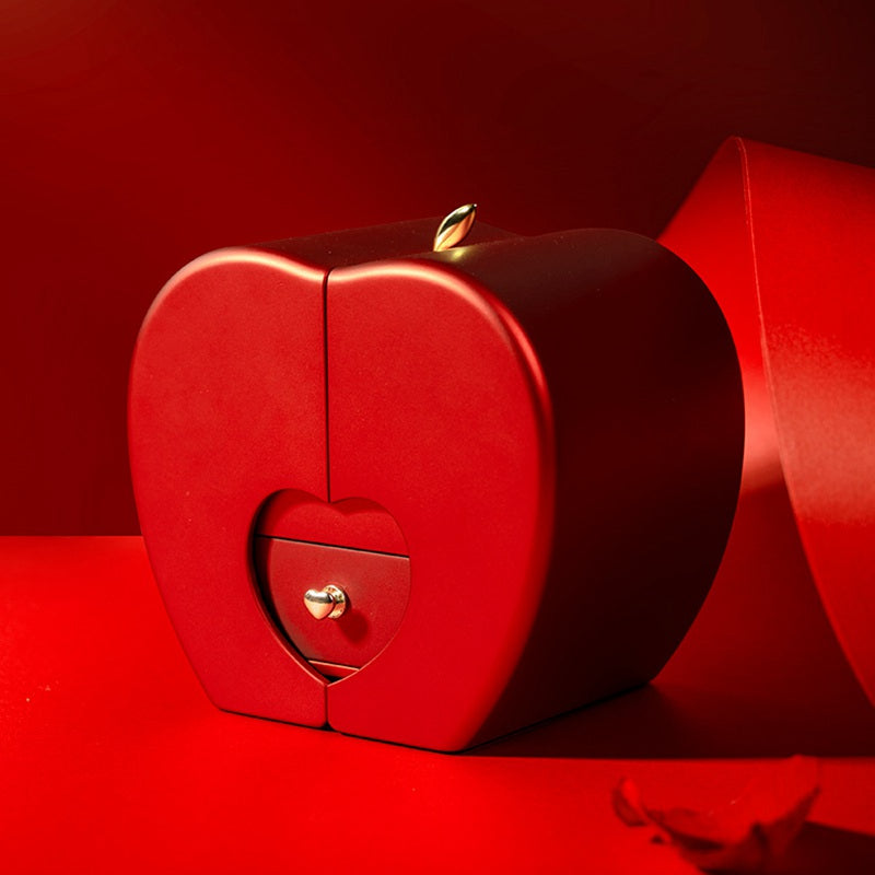 Closed red apple-shaped jewelry gift box with heart clasp