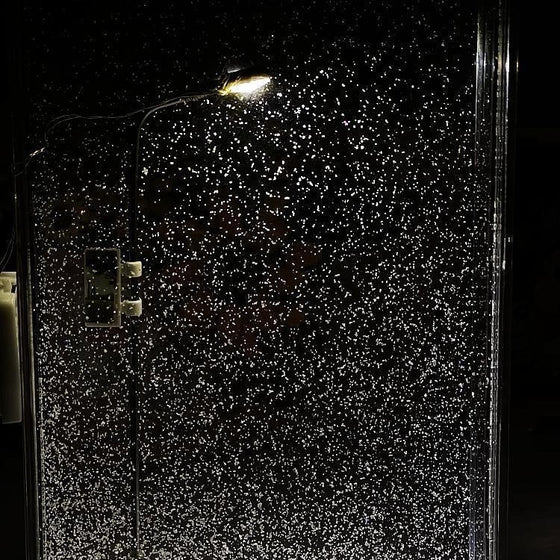 Close-up of snow swirling inside the acrylic frame of the street lamp night light