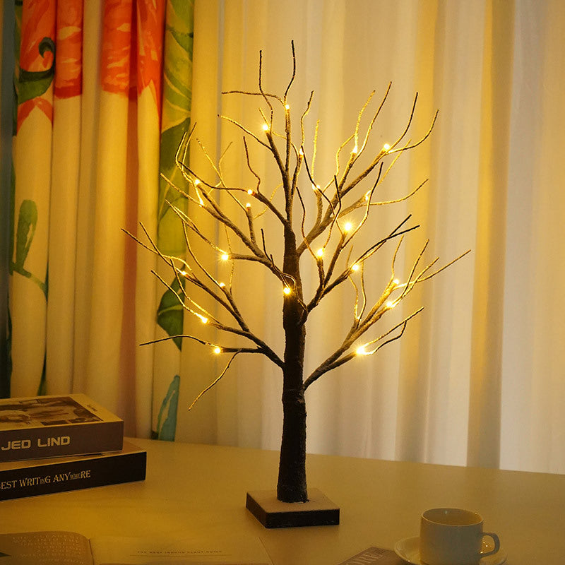 Lighted birch twig tree with warm white LEDs on a table near a window