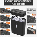 Paper shredder in use beside a home office desk