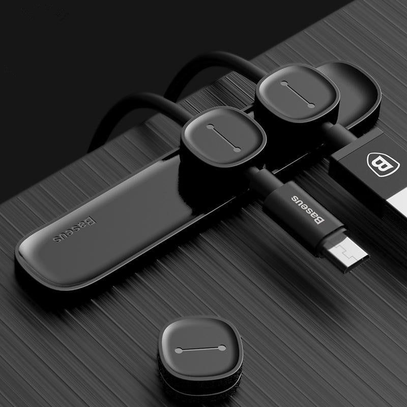 Magnetic cable organizer holding several cords together on a desk