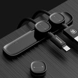 Magnetic cable organizer holding several cords together on a desk