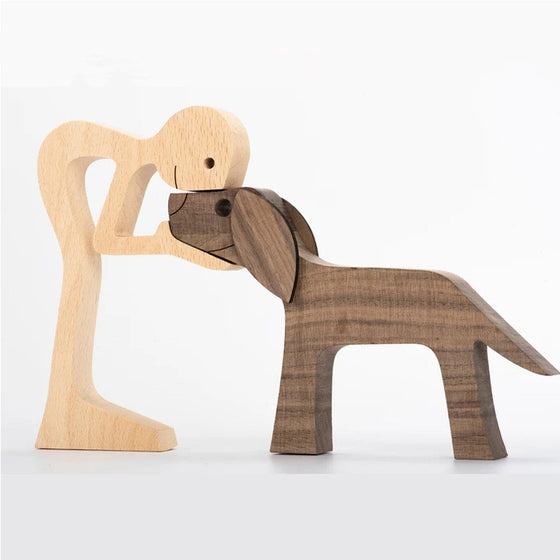 Wood carving of a man hugging a large dog, two-tone wood