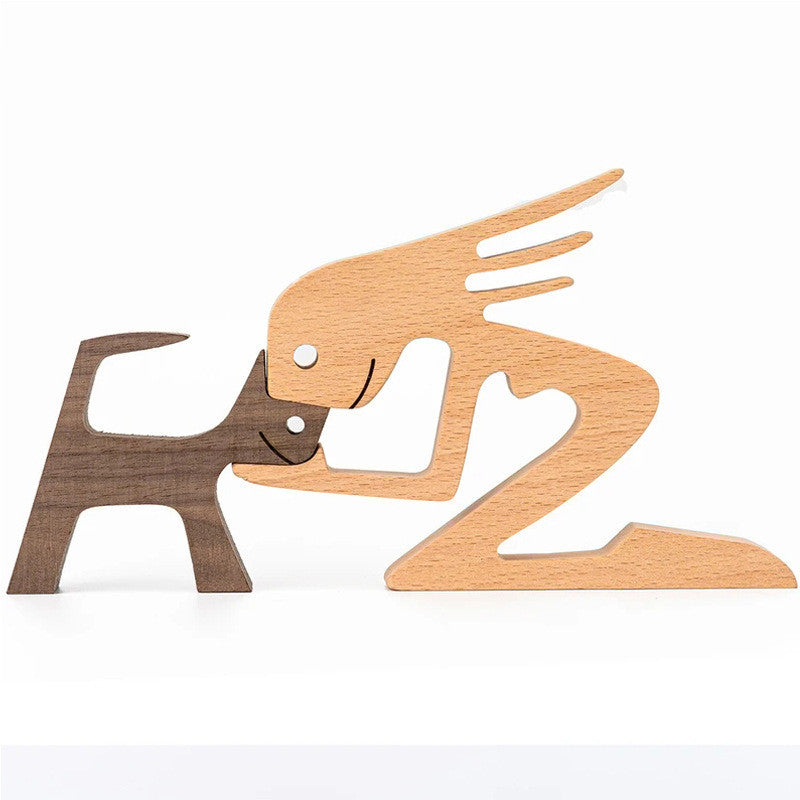 Wood carving of a man kneeling with a dark walnut dog