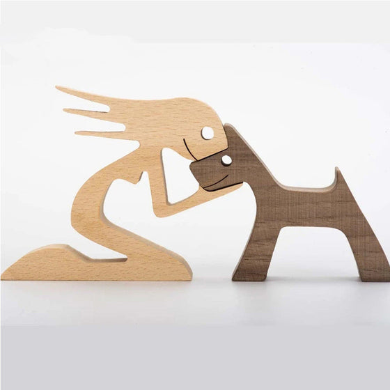 Wood carving of a man kneeling nose to nose with his dog, walnut finish