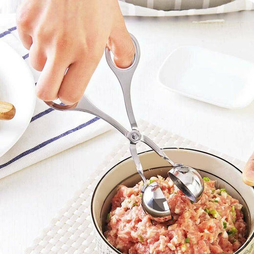 Stainless steel meatball maker held in hand