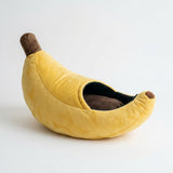 Banana-shaped pet bed shown open with the plush interior visible