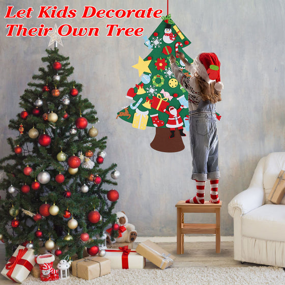Girl decorating a felt Christmas tree on the wall next to a Christmas tree