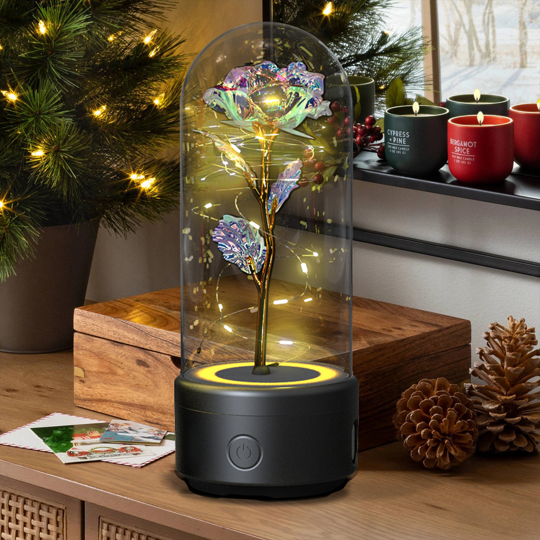 Blue rose LED lamp in a glass dome on a black speaker base in a living room