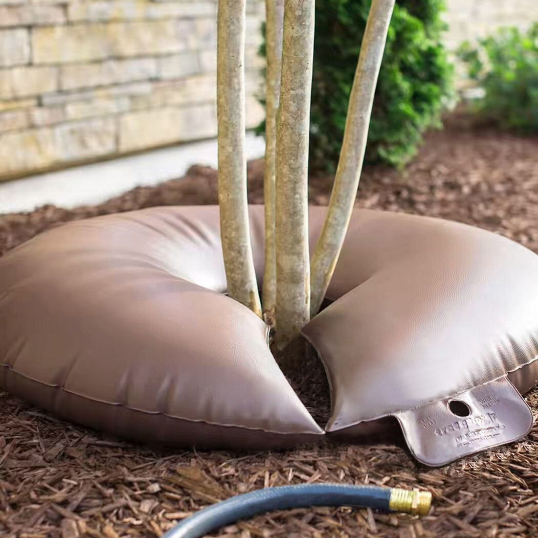 Brown 2-pack slow release tree watering bags wrapped around young tree trunk - alternate angle