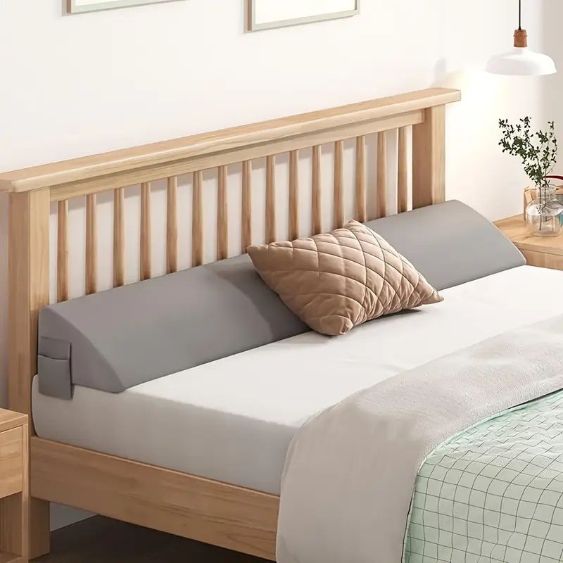 Gray bed gap filler pillow along a wooden headboard
