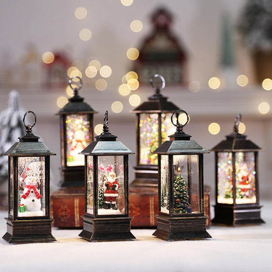 Set of four Christmas LED flickering flame lanterns lit on a table with bokeh lights
