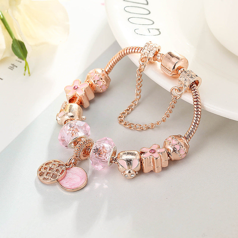 Charm bracelet with pink beads and round charm on a plate