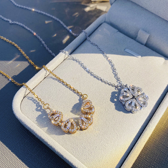 Gold-tone and silver-tone folding heart clover necklaces on a display