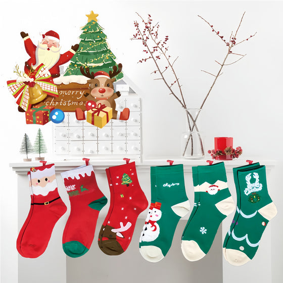Six Christmas socks hanging in a row beneath a Santa and reindeer display