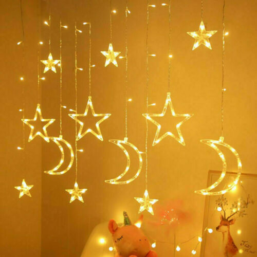 Warm white LED star and moon curtain fairy lights hanging in a window