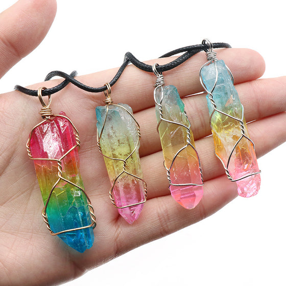 Hand holding four rainbow crystal pendants
