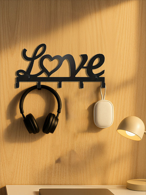 Love key holder holding headphones and earbuds on a wood wall