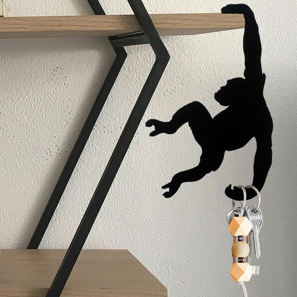 Monkey hook on a metal shelf holding a bunch of keys