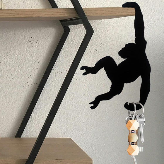 Monkey hook on a metal shelf holding a bunch of keys