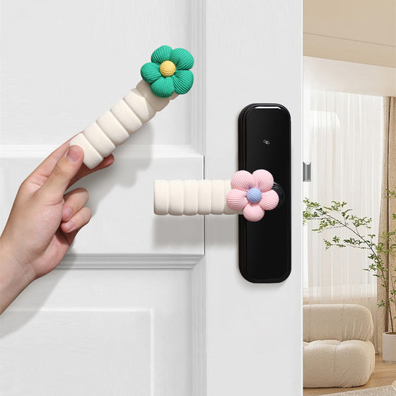 Hand holding a white soft handle cover with a green flower on a door