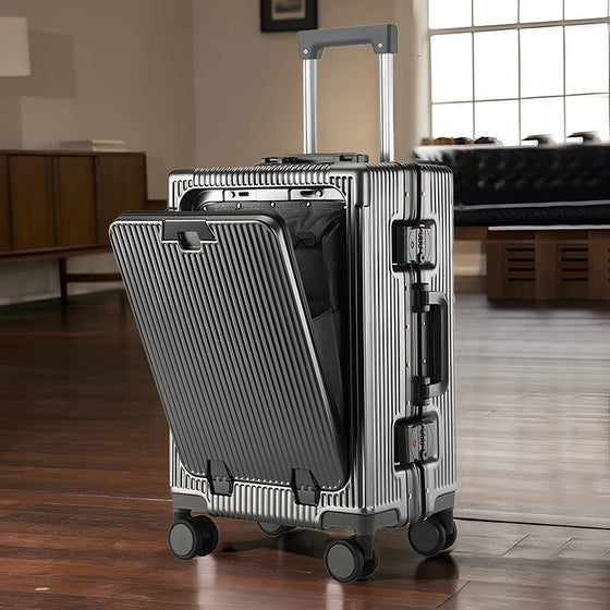 Open silver front-opening suitcase with a laptop compartment in a living room