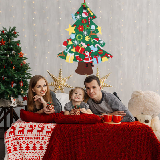 Family in a living room with a felt Christmas tree hanging on the wall