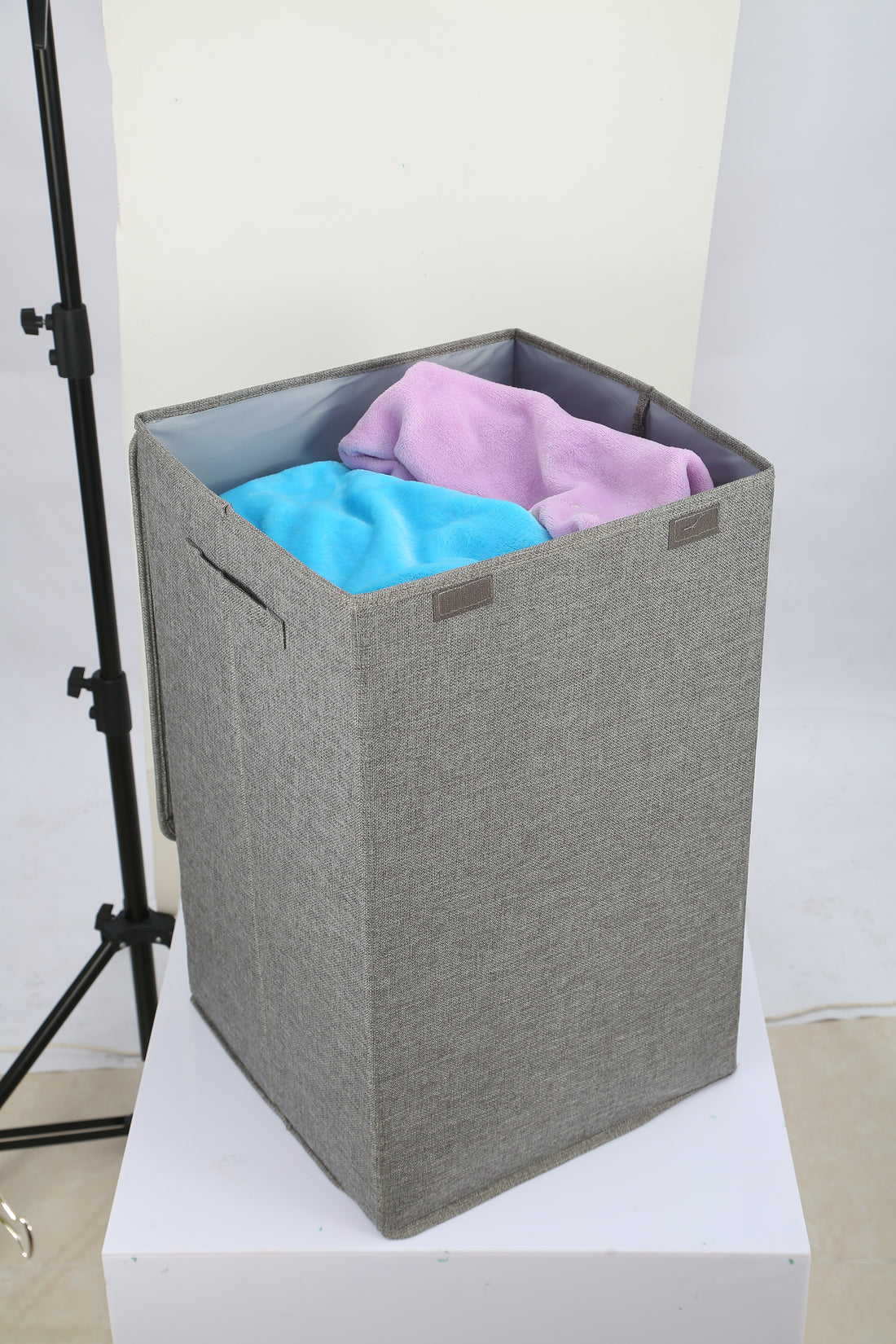 Grey laundry hamper full of clothes