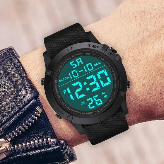Digital sports watch worn on a wrist with the backlight on