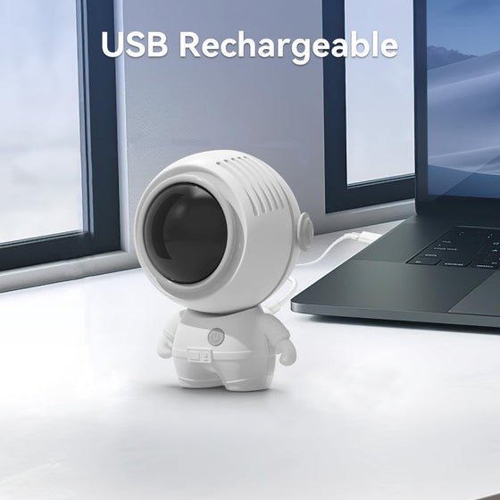 White astronaut fan on a desk by a window, USB rechargeable