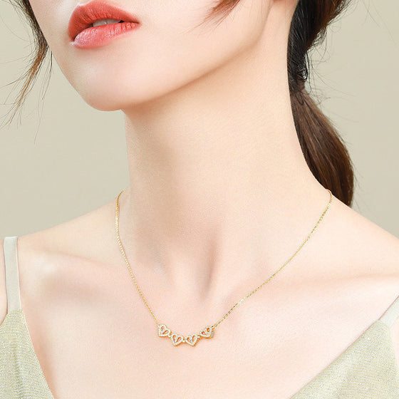 Model wearing the hearts opened in a row on the necklace