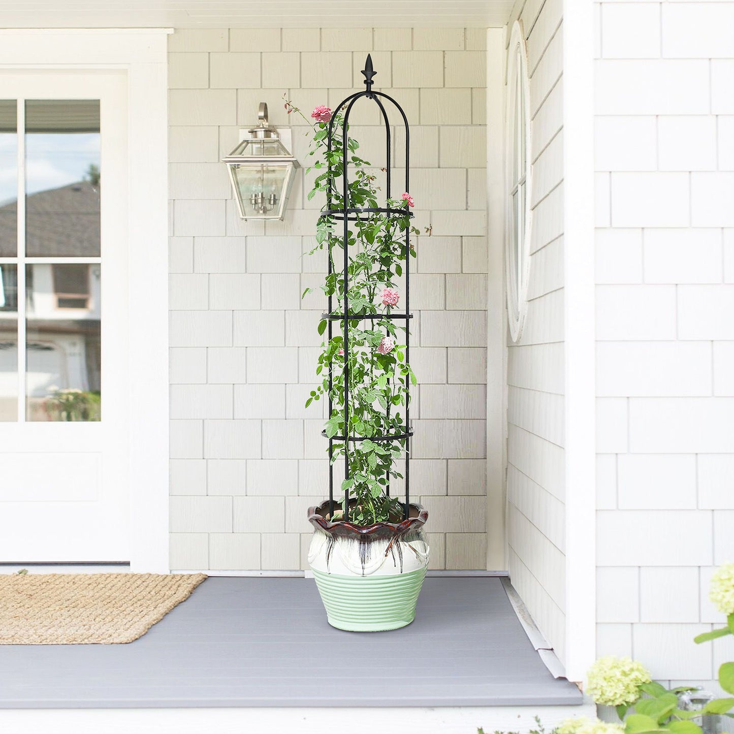 6.2 ft tall black garden obelisk trellis supporting climbing plants in flower bed - close-up detail
