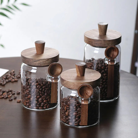 Three coffee jars filled with beans on a dark table