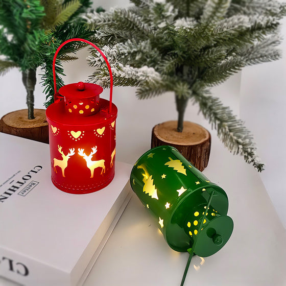Red and green Christmas LED candle lanterns with reindeer cutouts under a Christmas tree