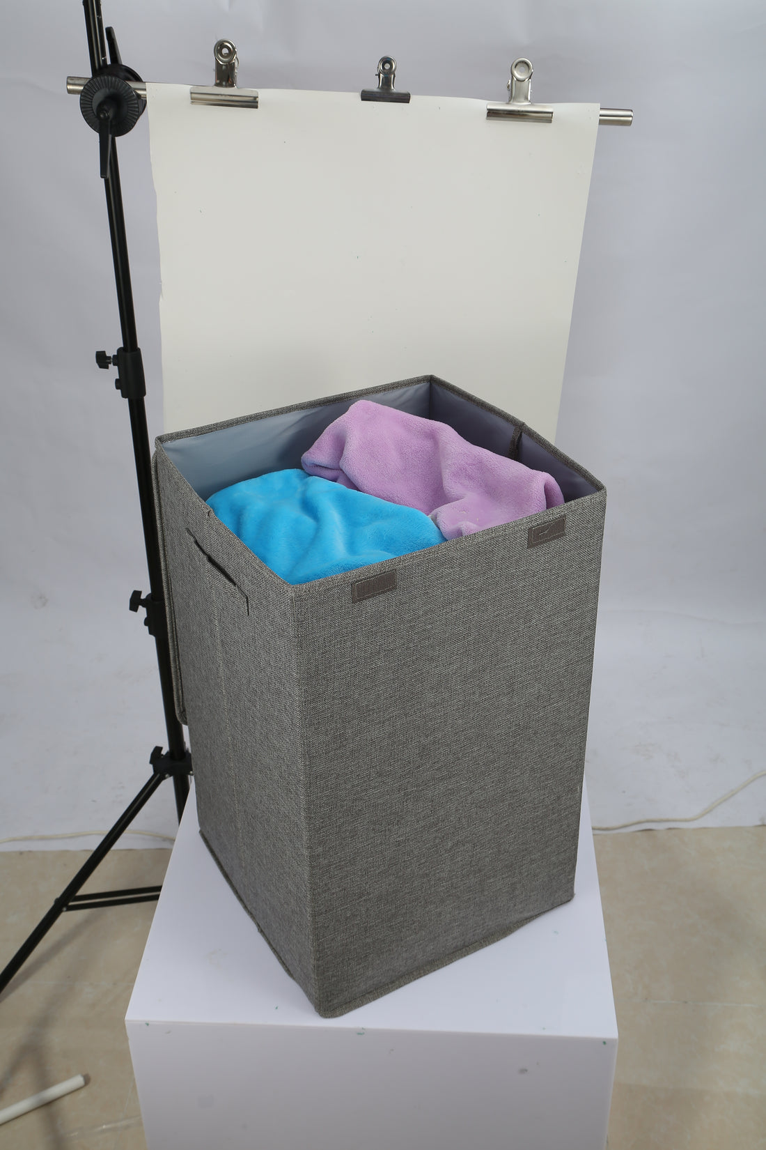 Grey laundry hamper with clothes and lid open