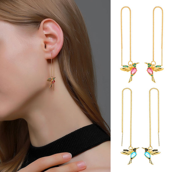 Woman wearing hummingbird threader earrings, with two pairs shown beside her